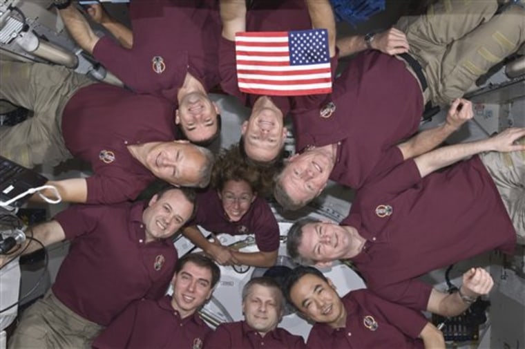 The International Space Station's crew and Atlantis' astronauts form a circle in zero-gravity for a portrait: Atlantis' crew consists of NASA astronauts Chris Ferguson, Doug Hurley, Sandy Magnus and Rex Walheim; the space station's crew members are Japanese astronaut Satoshi Furukawa, NASA astronauts Ron Garan and Mike Fossum, and Russian cosmonauts Andrey Borisenko, Alexander Samokutyaev and Sergei Volkov. The U.S. flag pictured was flown on the first space shuttle mission and is being presented to the space station crew.